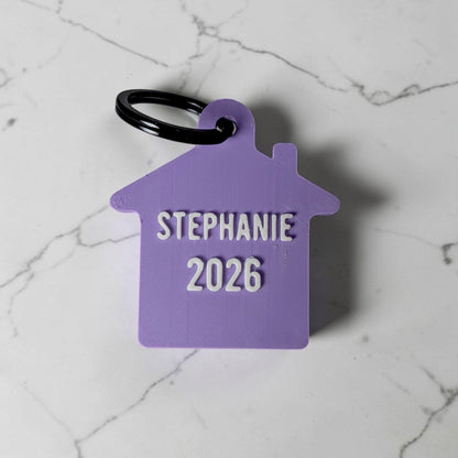 Paarse sleutelhanger huisje met naam en jaartal 2026 als cadeau voor een nieuw huis